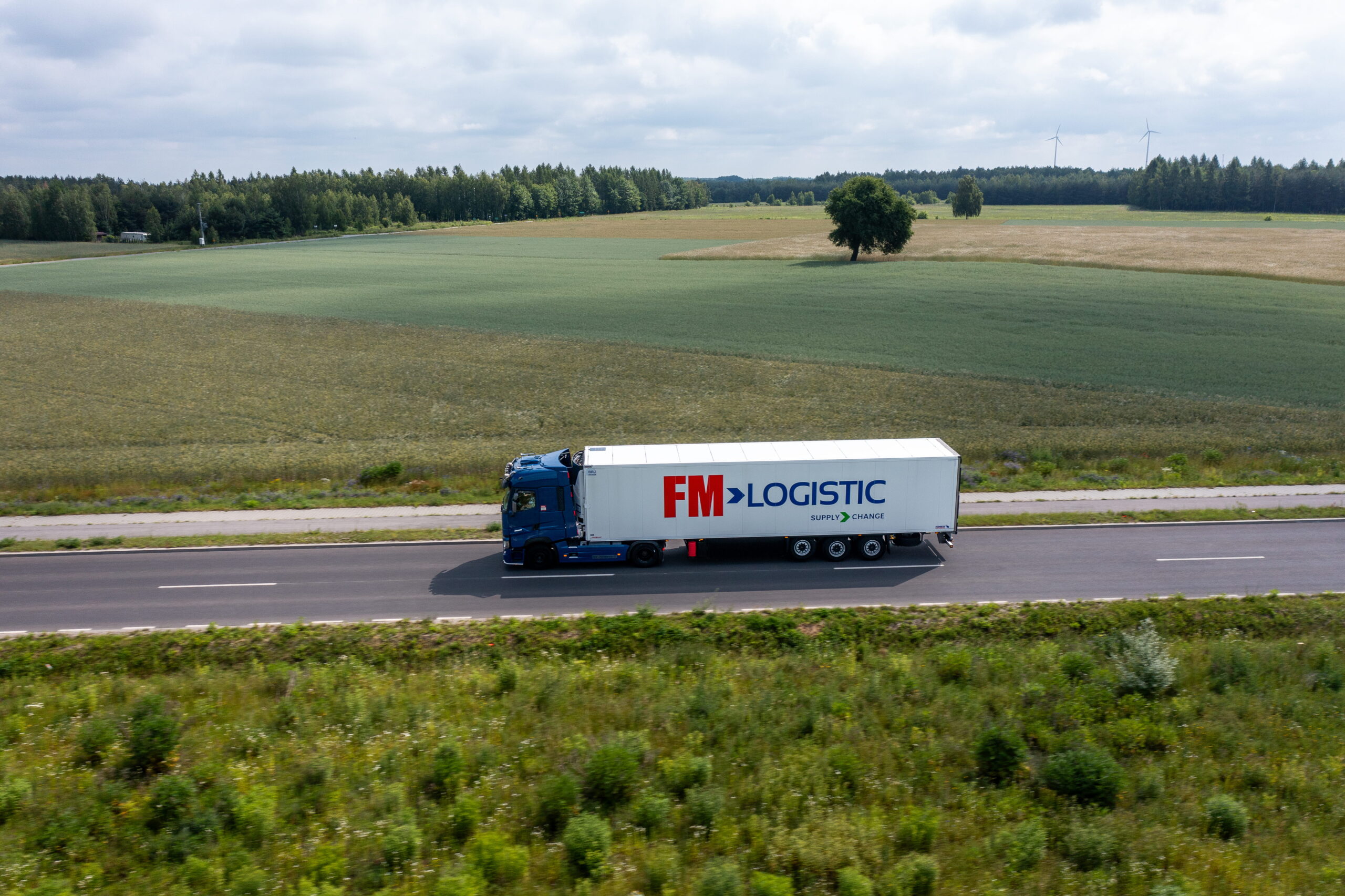 Międzynarodowy transport drobnicowy. Ciężarówka FM Logistic na drodze.