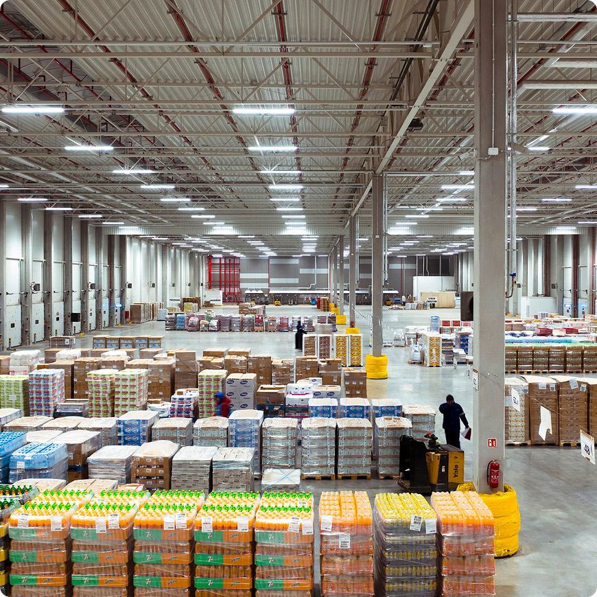Interior of a large FM Logistic warehouse with pallets of products and boxes arranged in the storage area.